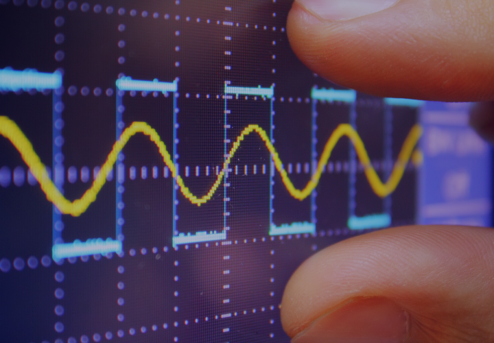 image of wave form monitor with fingers measuring perfect sine wave